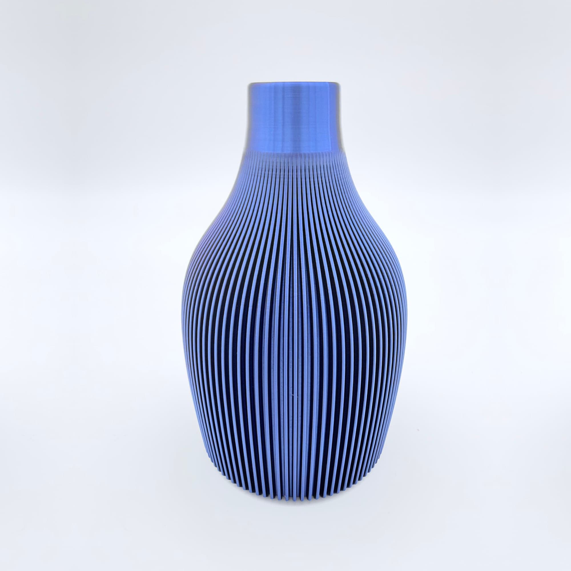 The Arcadia vase, 3D printed in glossy blue, with fine vertical ribs from its shoulder to its base