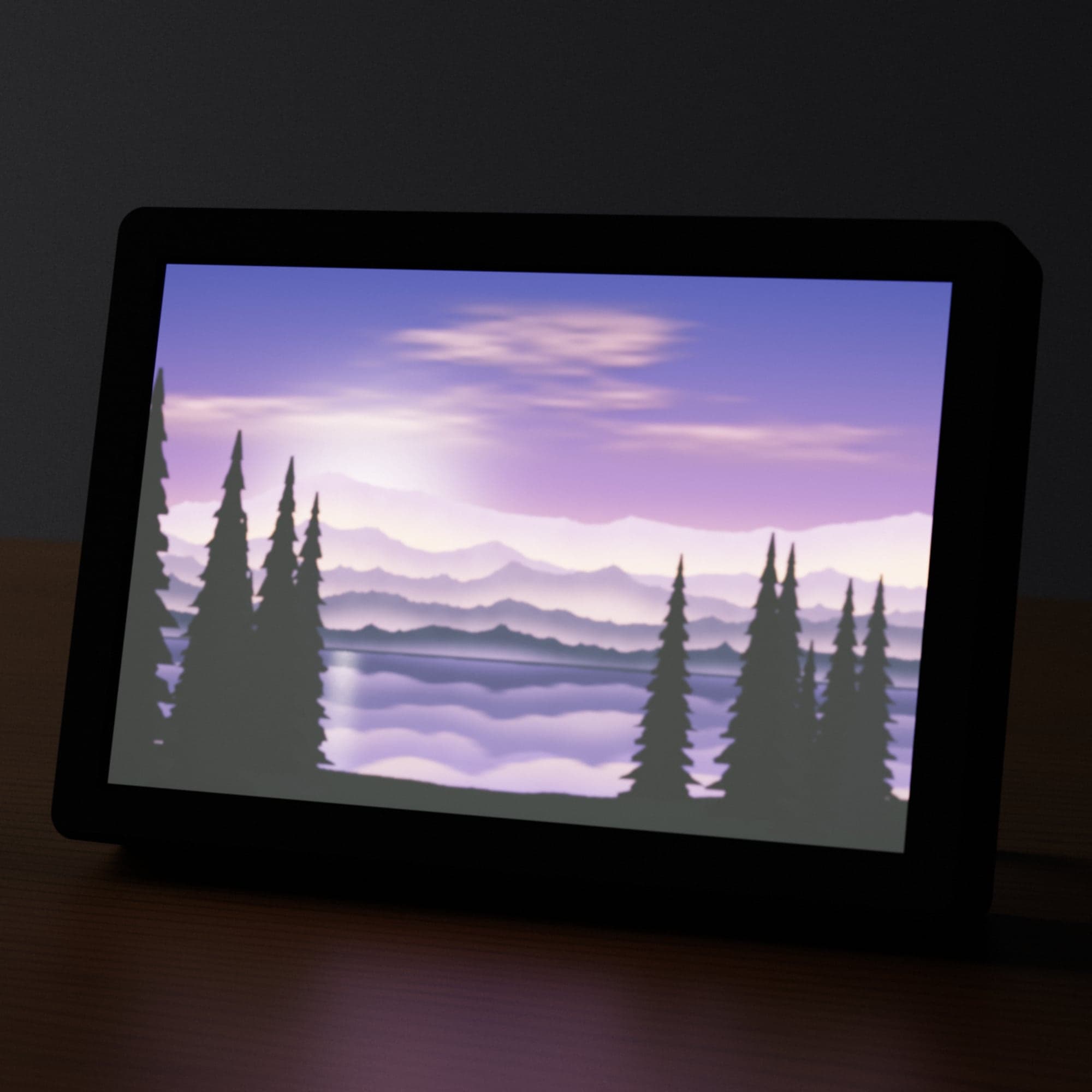 A Full Color Lithophane of a mountain lake at dusk, lit from behind in a black frame on a desk